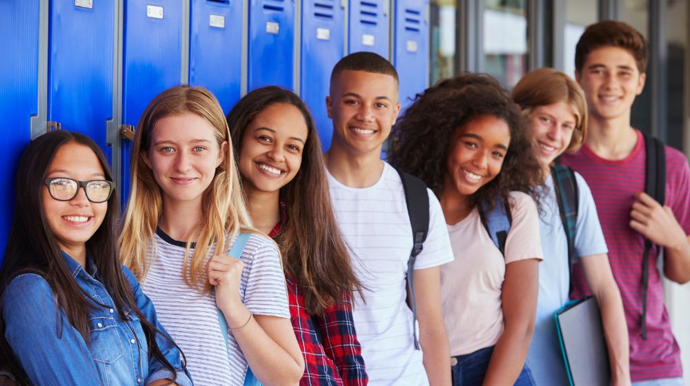 teenagers leaning on lockers at school